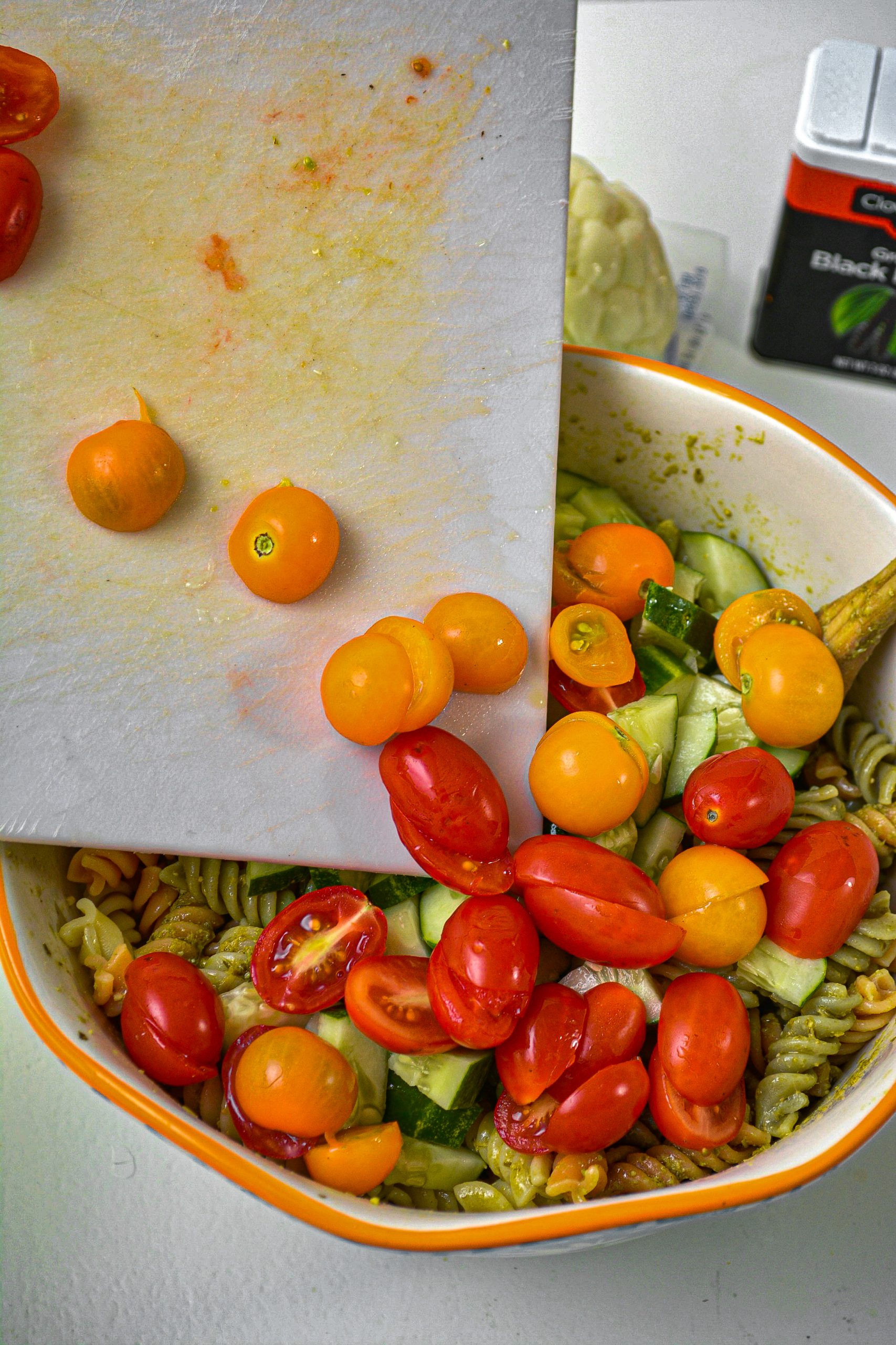 Place 2 cups of cherry tomatoes sliced in half into the pasta, and mix well.