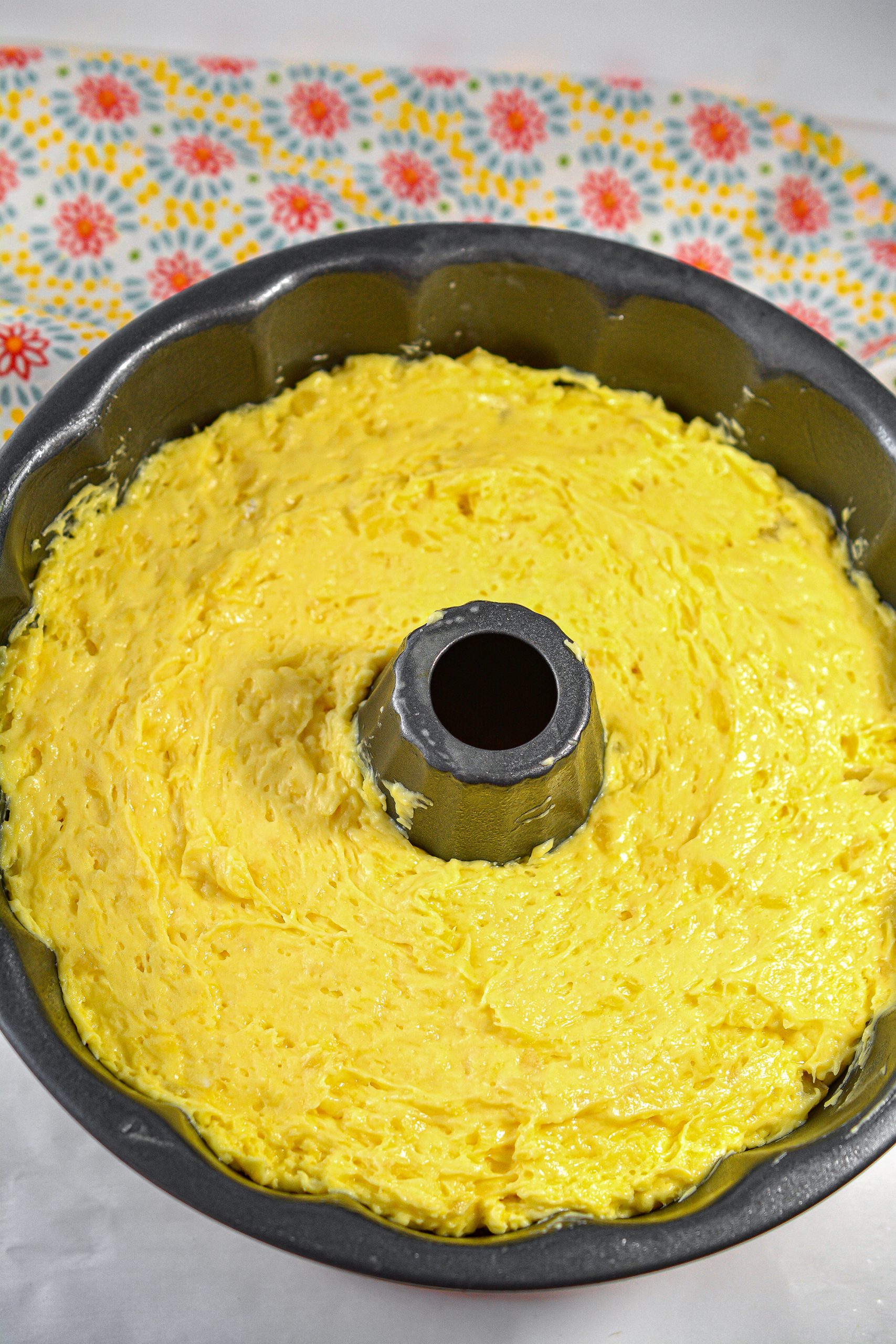 Layer the cake batter over the pineapple slices in the bundt pan.