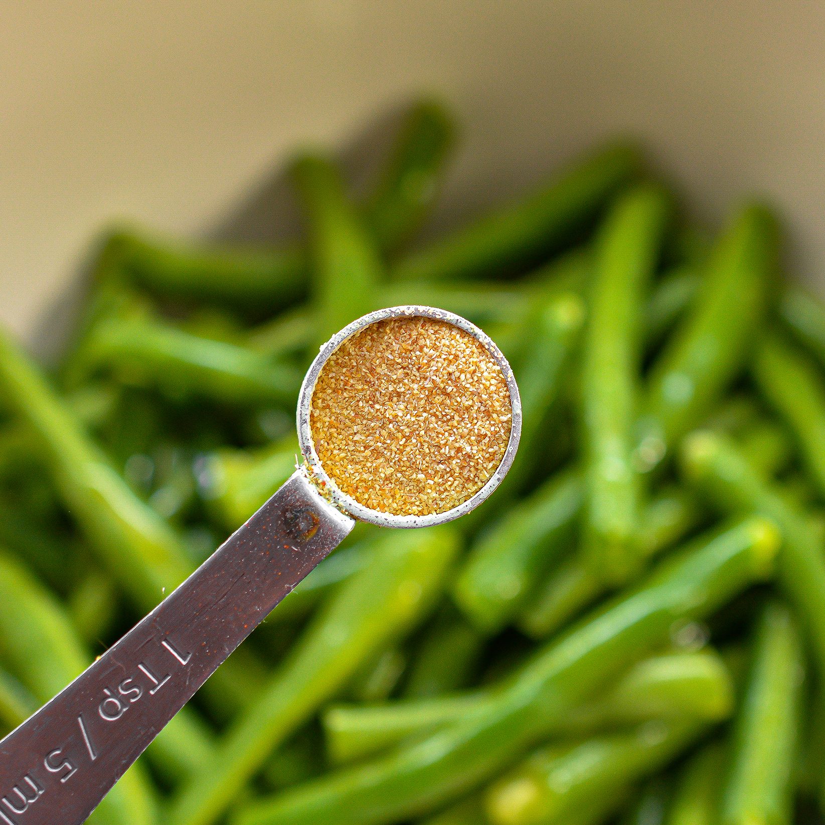 In a mixing bowl, toss the trimmed green beans in the remaining olive oil, garlic powder, and salt and pepper to taste.