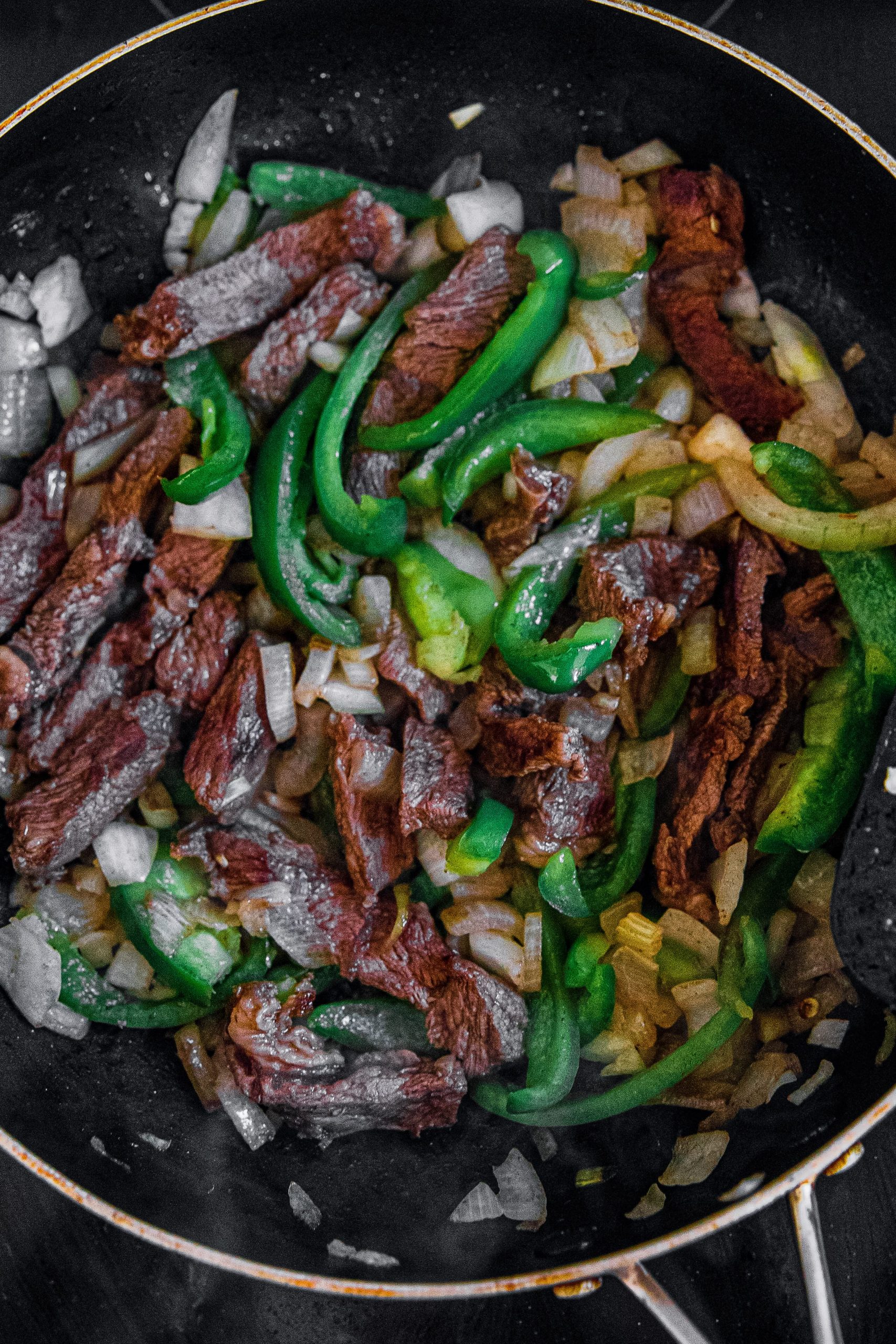 Add onions and green bell peppers to beef; cook and stir until softened, 5 to 10 minutes.