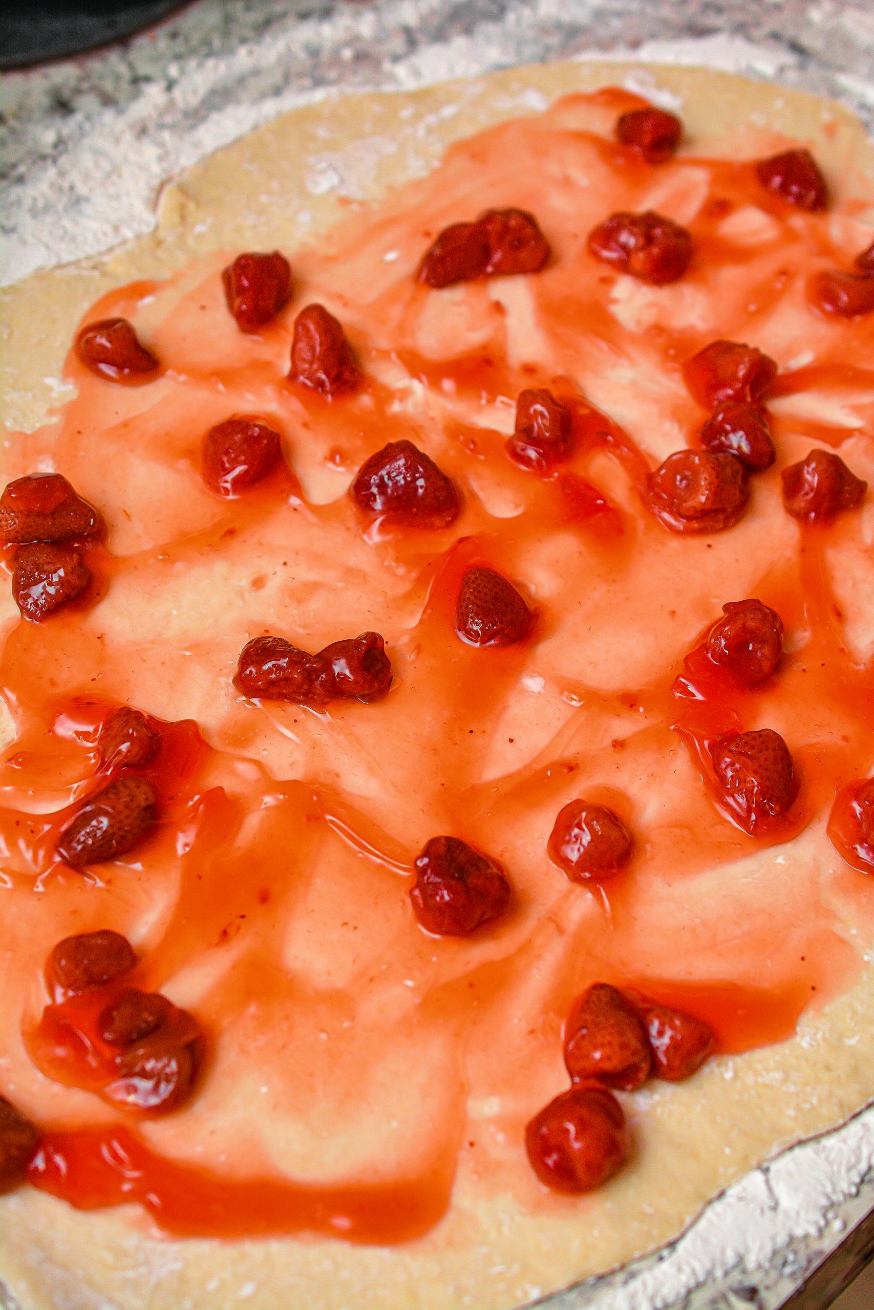  Layer the strawberry filling on top of the dough, and then sprinkle with ½ tsp of the sugar and 2 tsp of cinnamon.