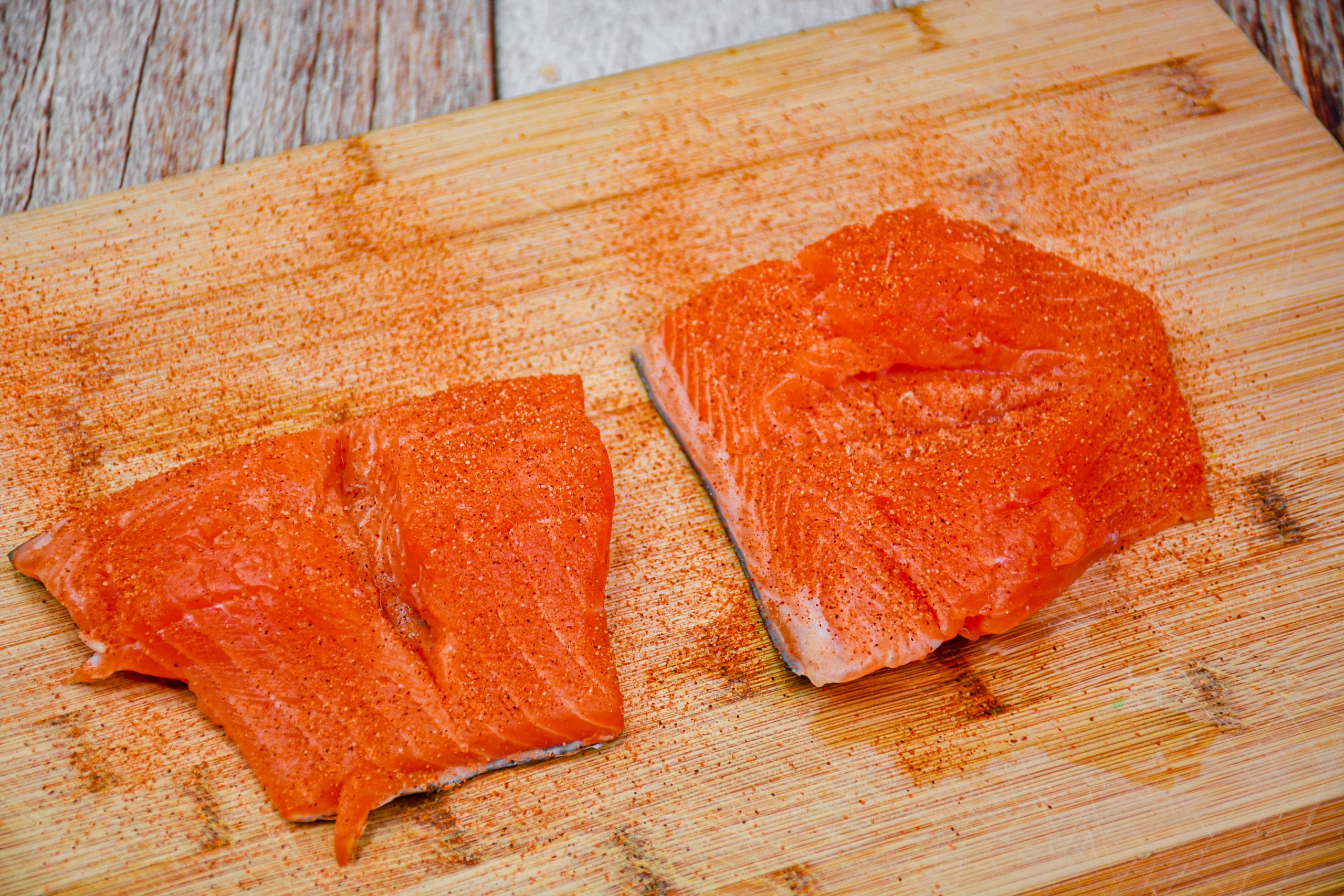 Cut a slit through the middle of each salmon fillet and season the whole salmon with cajun seasoning