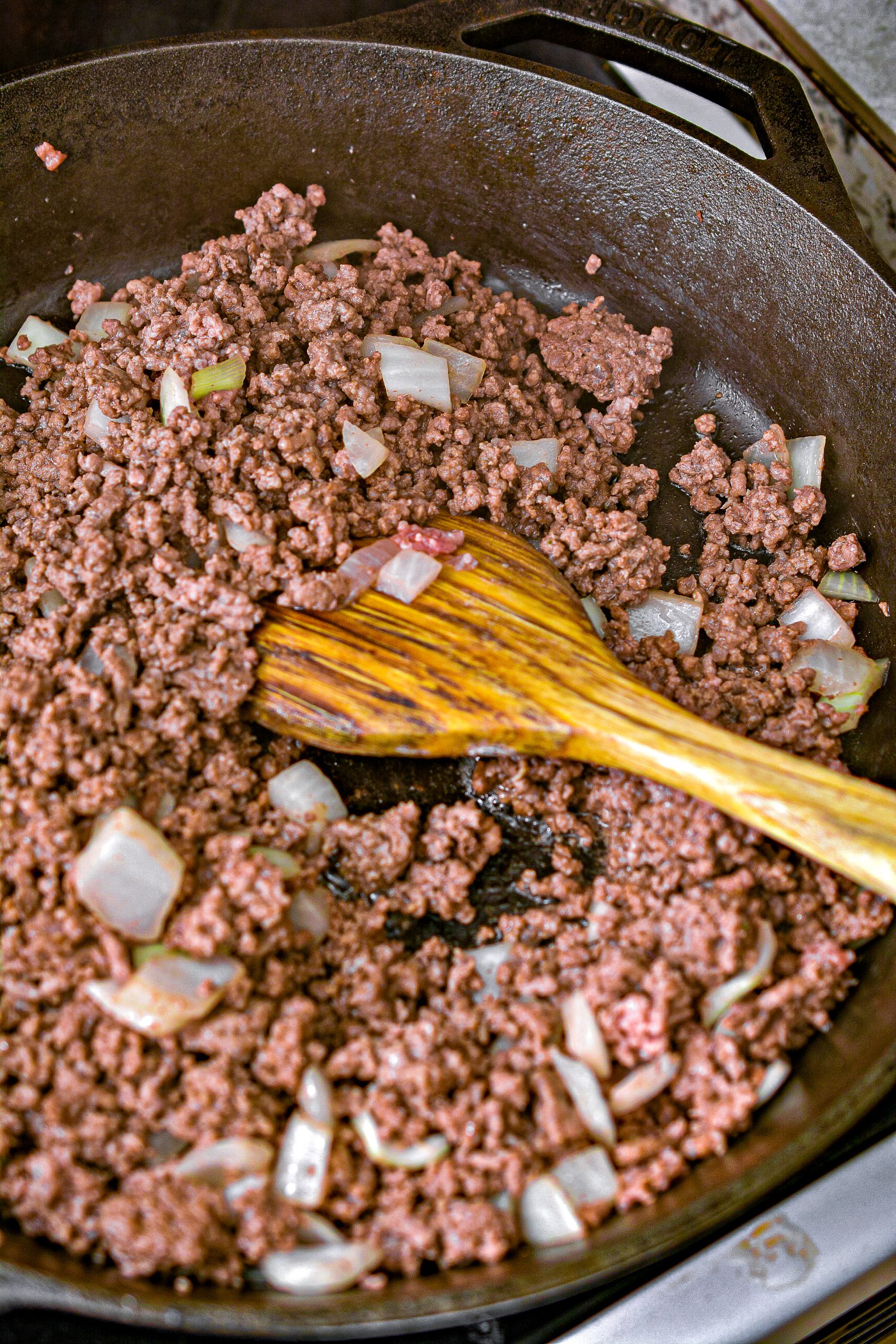 Cook the ground beef and onions in a skillet over medium-high heat on the stove until the meat is completely browned and the onions are starting to become tender.