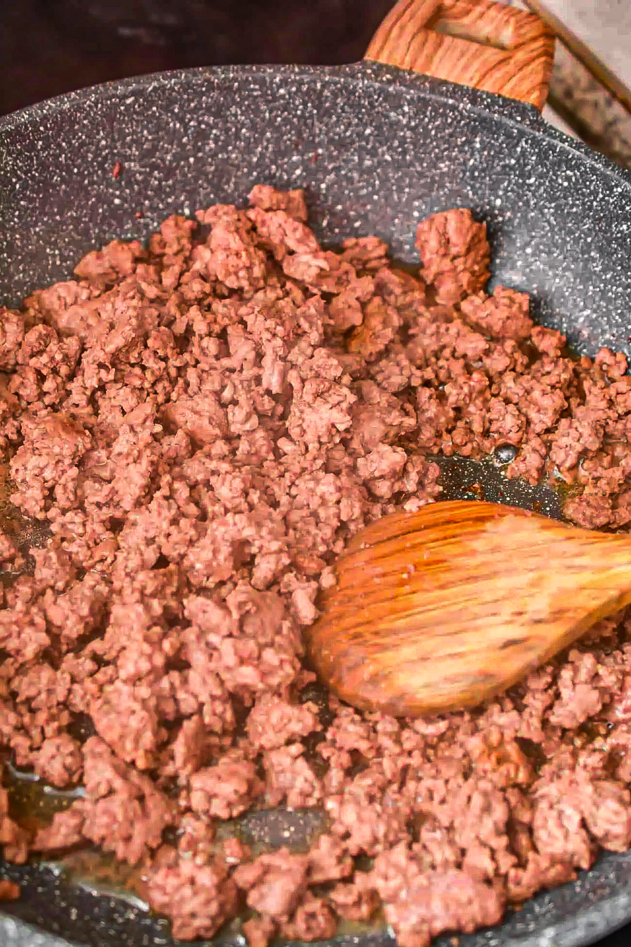 Saute the ground beef in a skillet over medium-high heat on the stove until it is completely browned. Drain any excess grease.