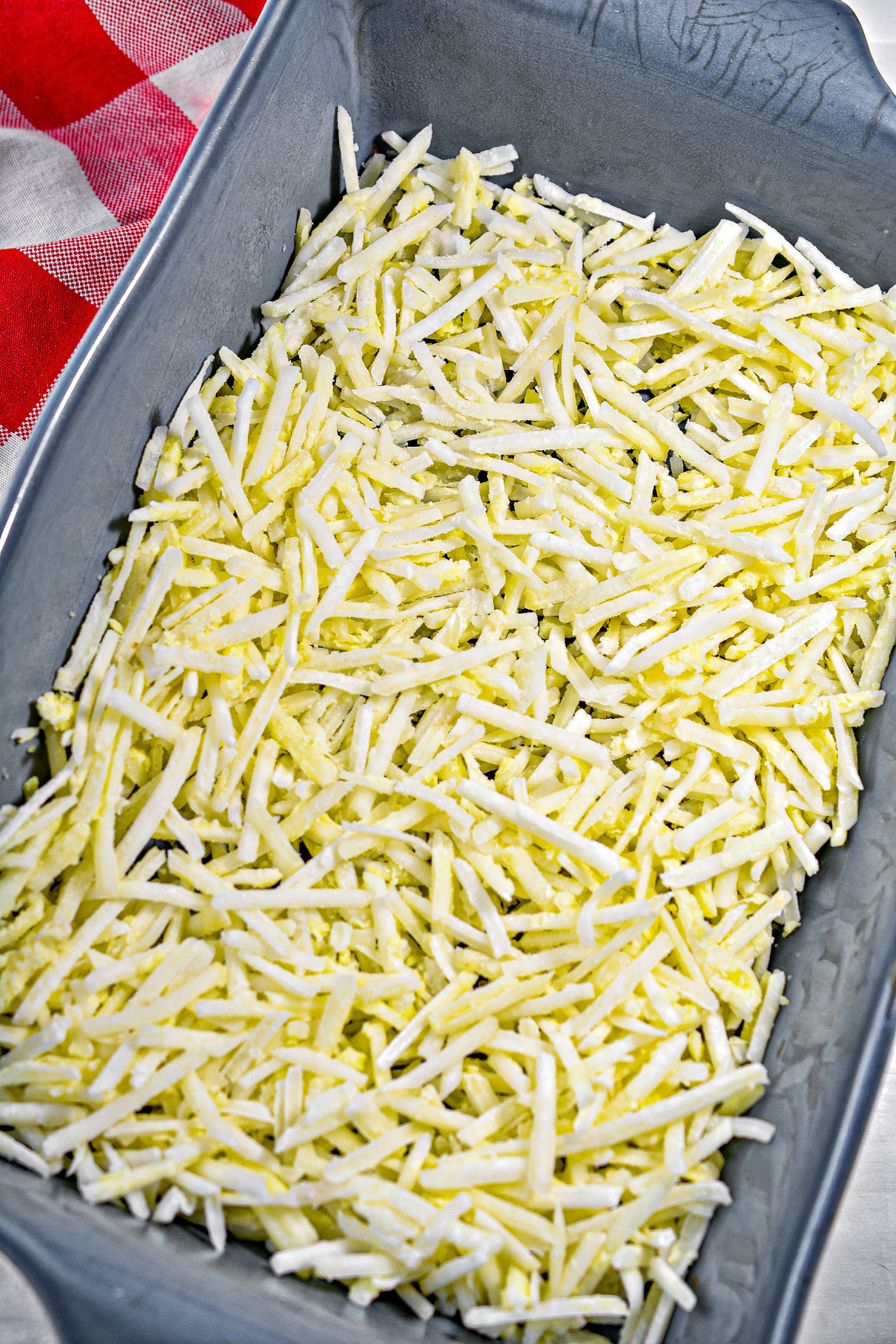 Mix together the hashbrowns and butter, and place into the bottom of a well-greased baking dish.