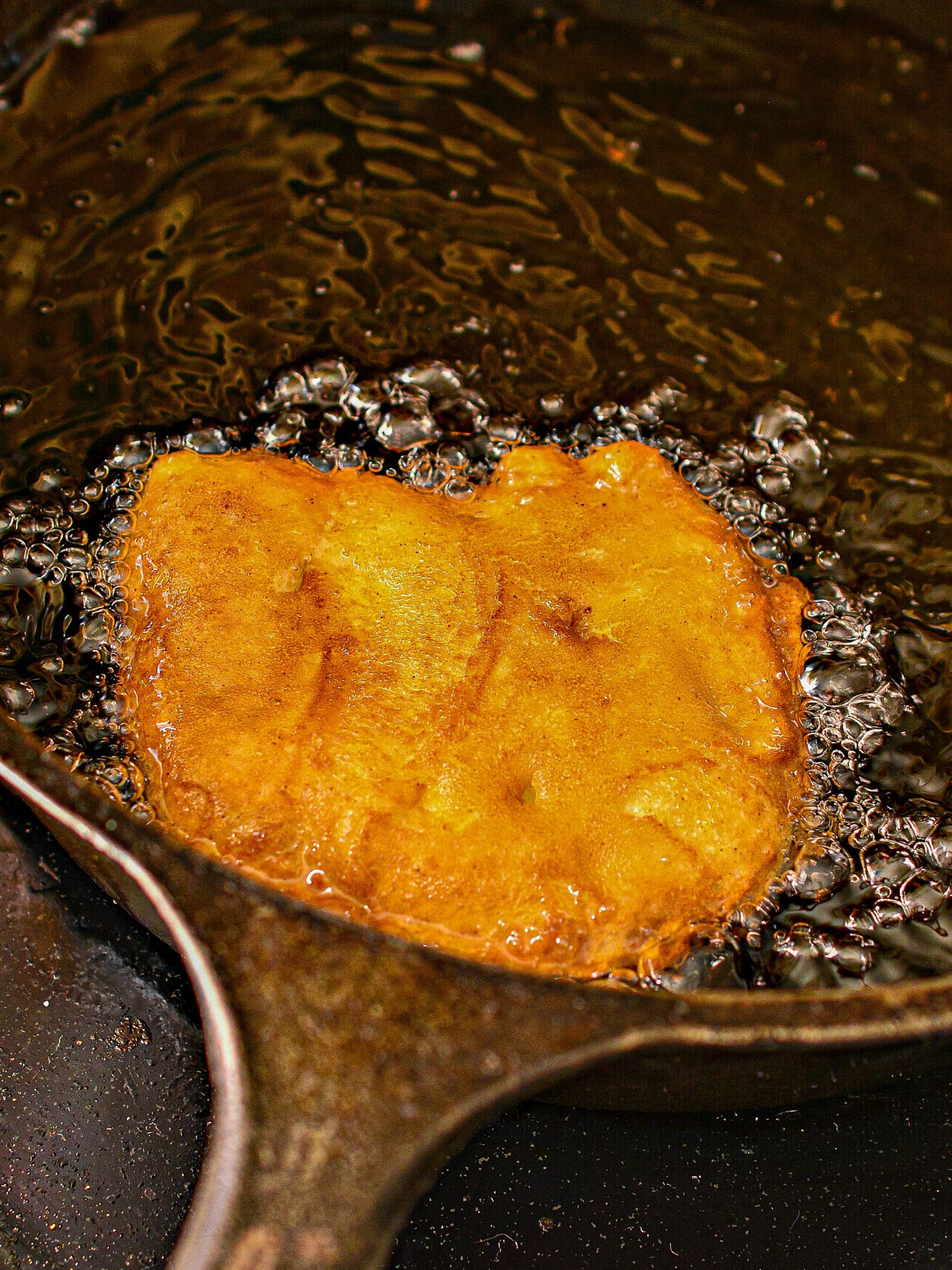 Place ⅓ - ½ cup of the batter into the heated oil, and press it down flat with a metal spatula or cooking spoon. 