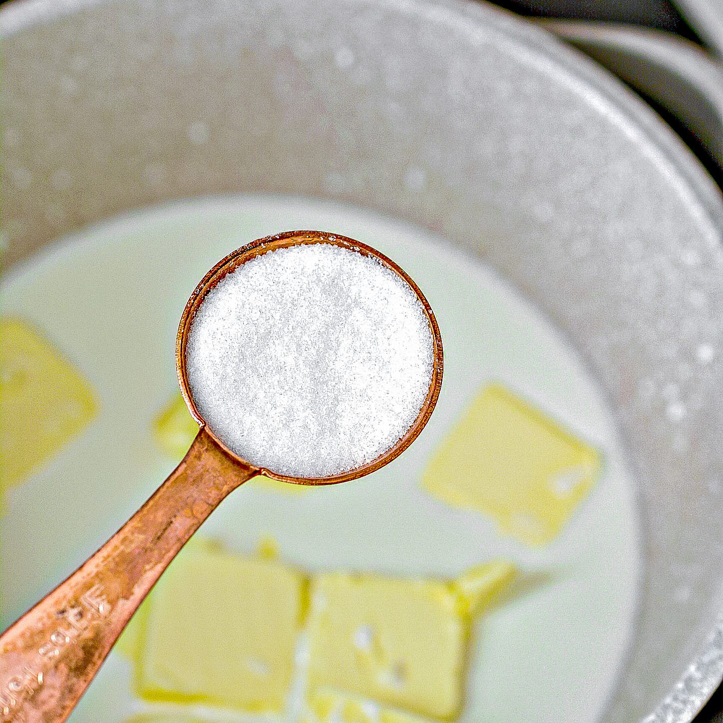 In a saucepan over low heat, add the water, half and half, 8 tbsp butter cut into pieces, salt and sugar. Cook over low heat, stirring often until the butter and sugar are completely melted.