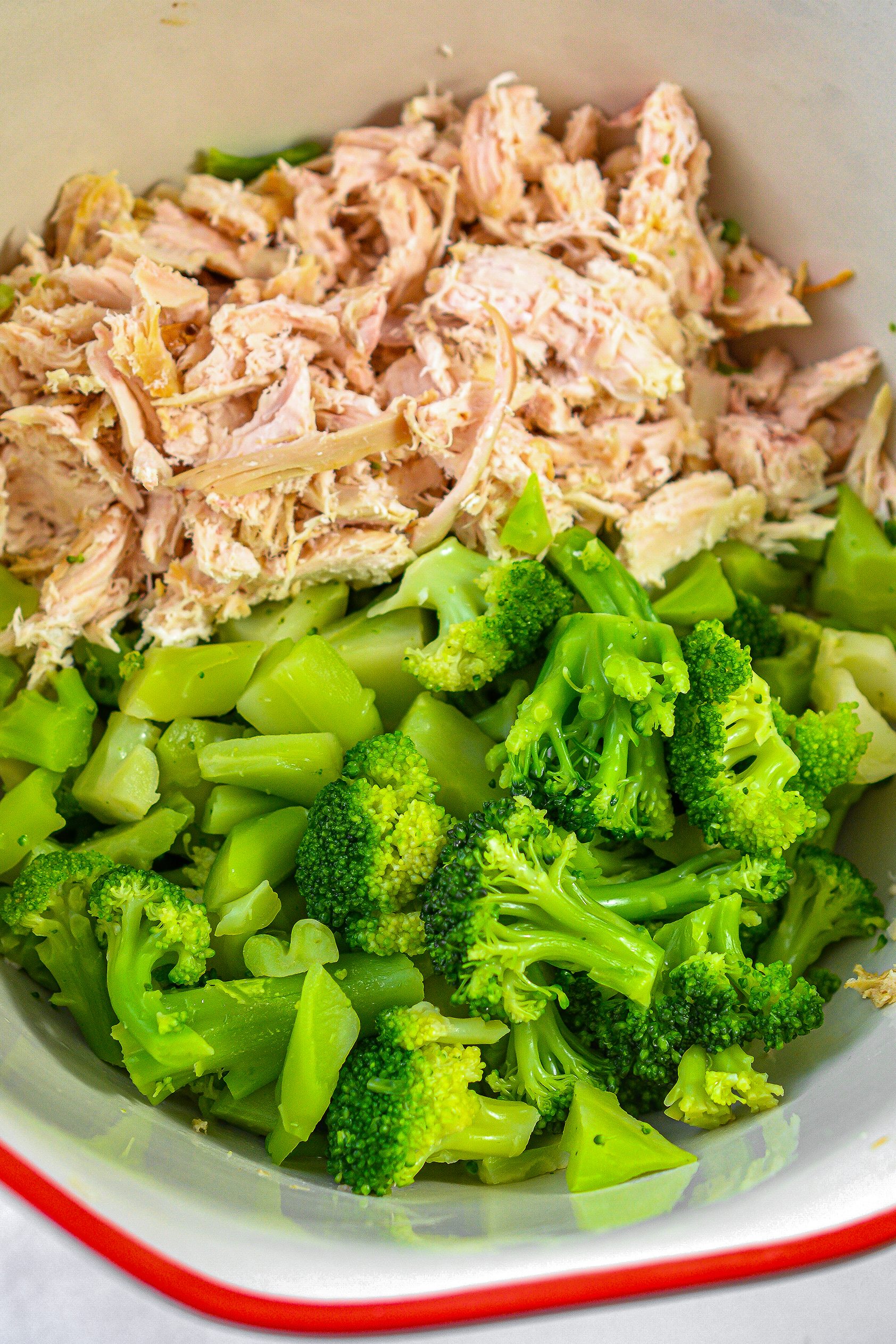 In a large mixing bowl, combine the shredded chicken and broccoli.