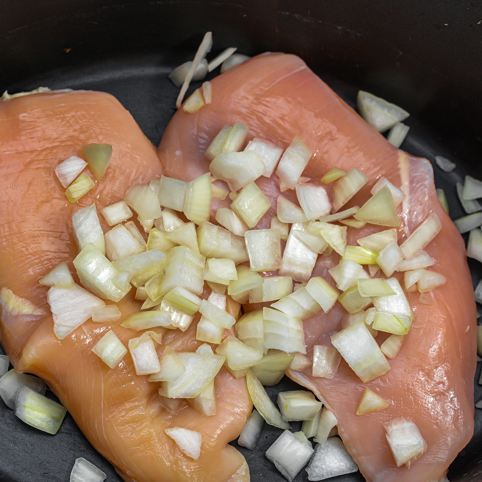 Place the chicken in the crockpot.  Add in the onions and corn.