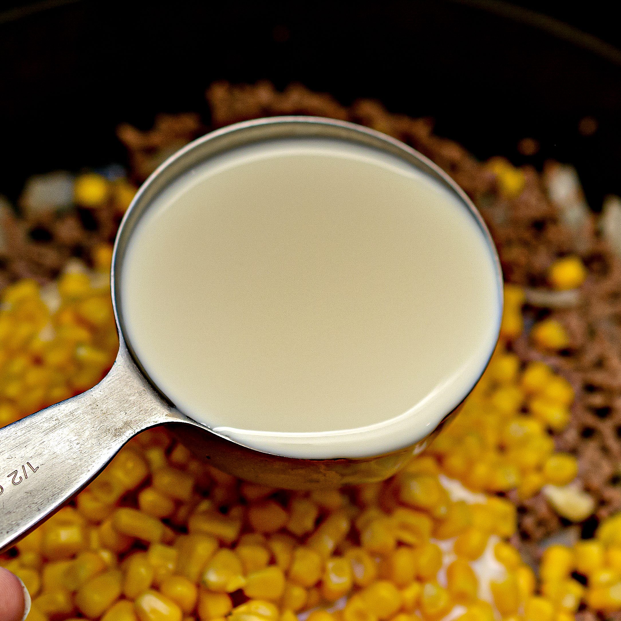 Mix in the soup, milk corn, sour cream, 1 cup of the cheese, and salt and pepper to taste