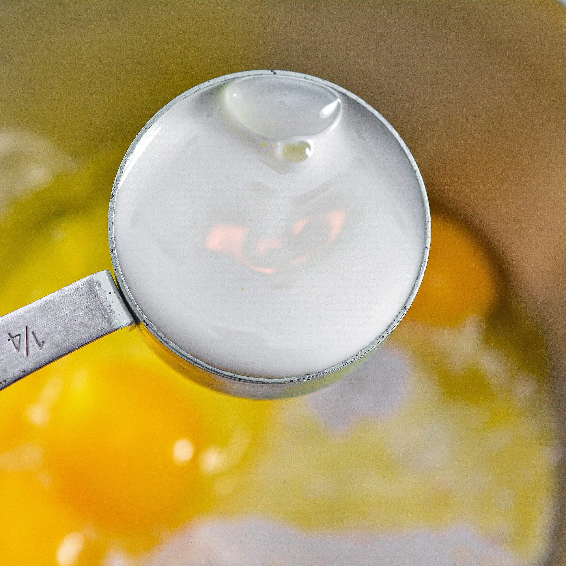 In a mixing bowl, beat together the cake mix, sour cream, oil, eggs, and ¼ cup of milk until smooth.