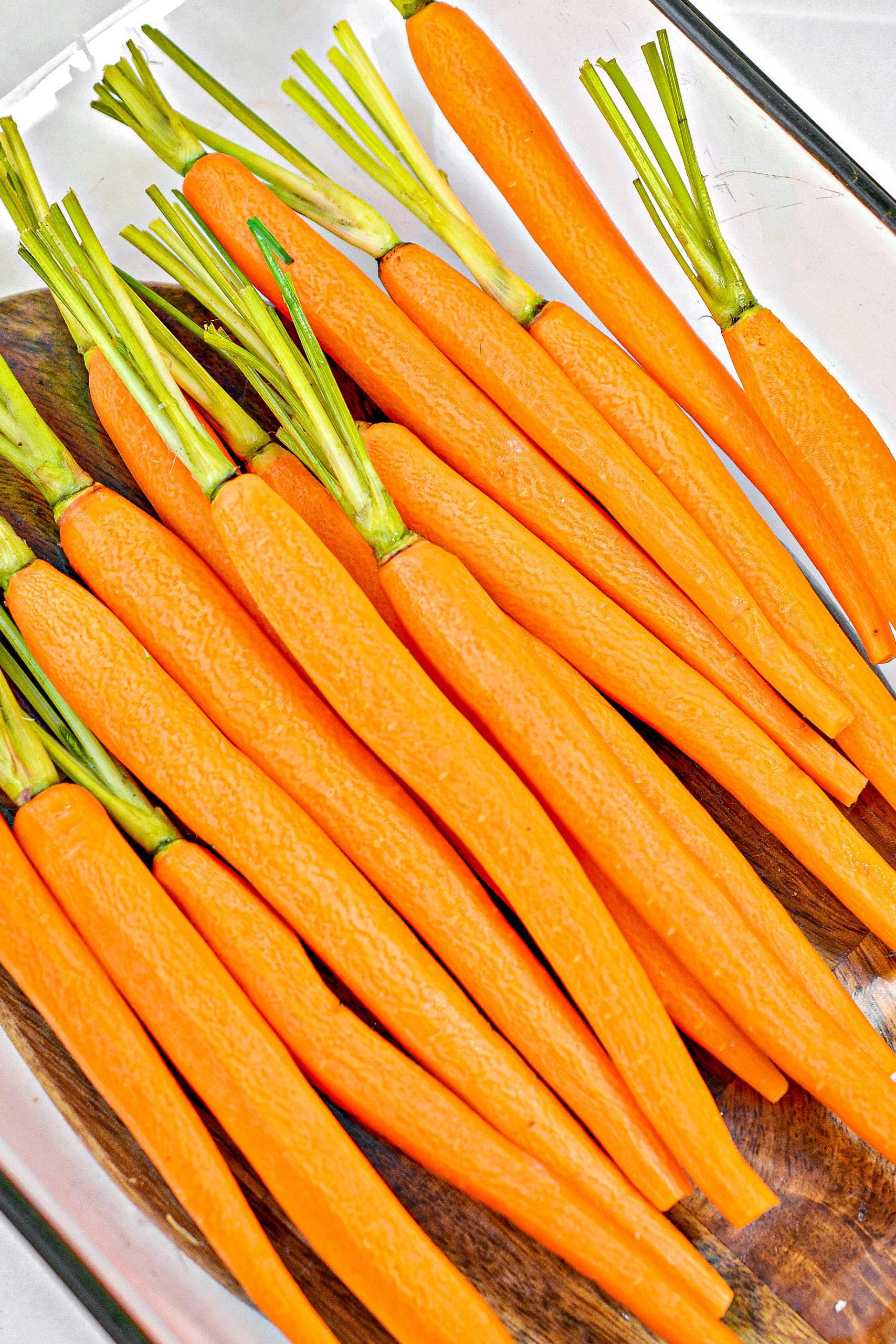 Place the carrots that have been peeled and have had their tops trimmed into a well-greased 9x13 baking dish.