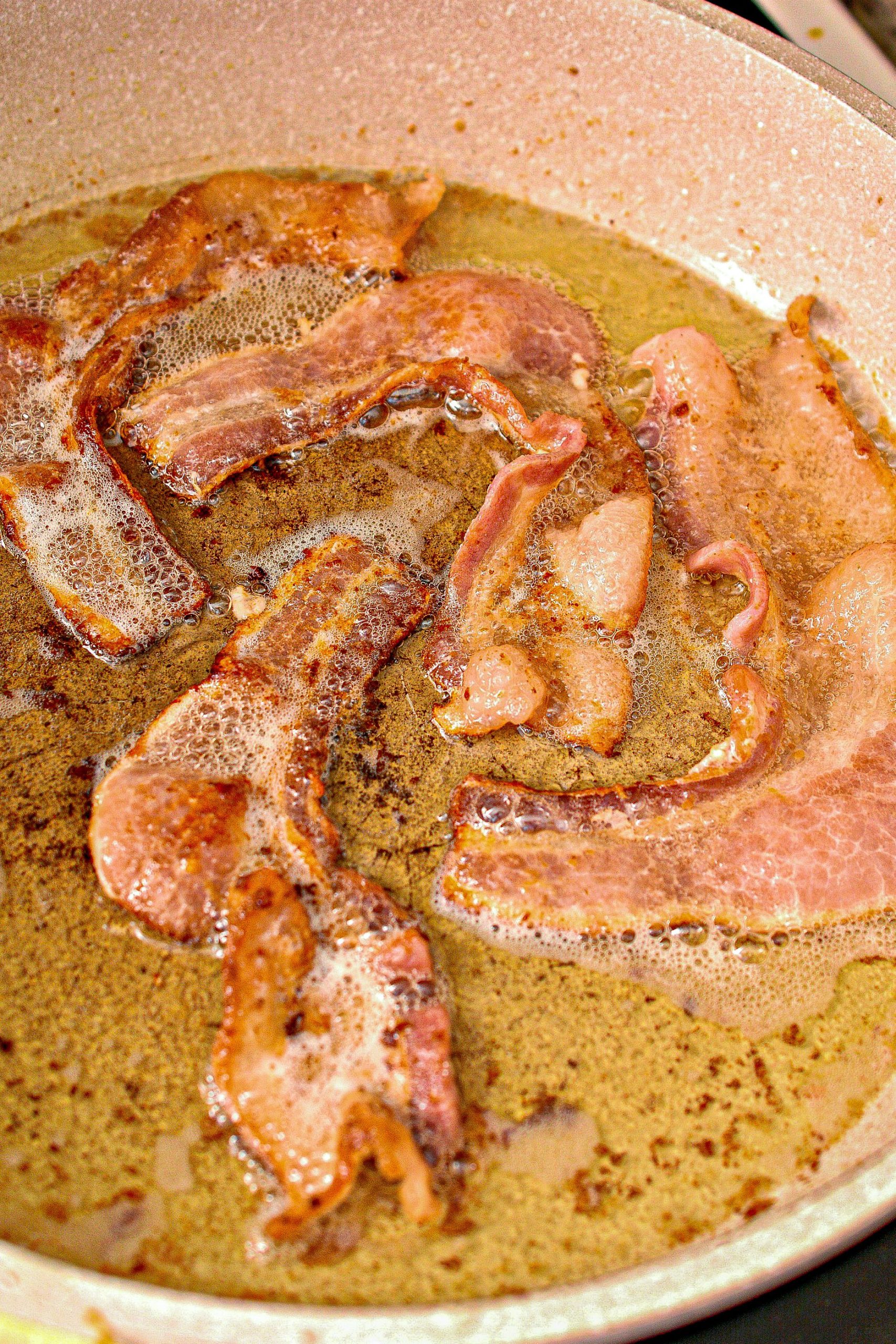 While the chicken is cooking, partially cook the bacon until the fat is all rendered from it, but it is not crispy yet.