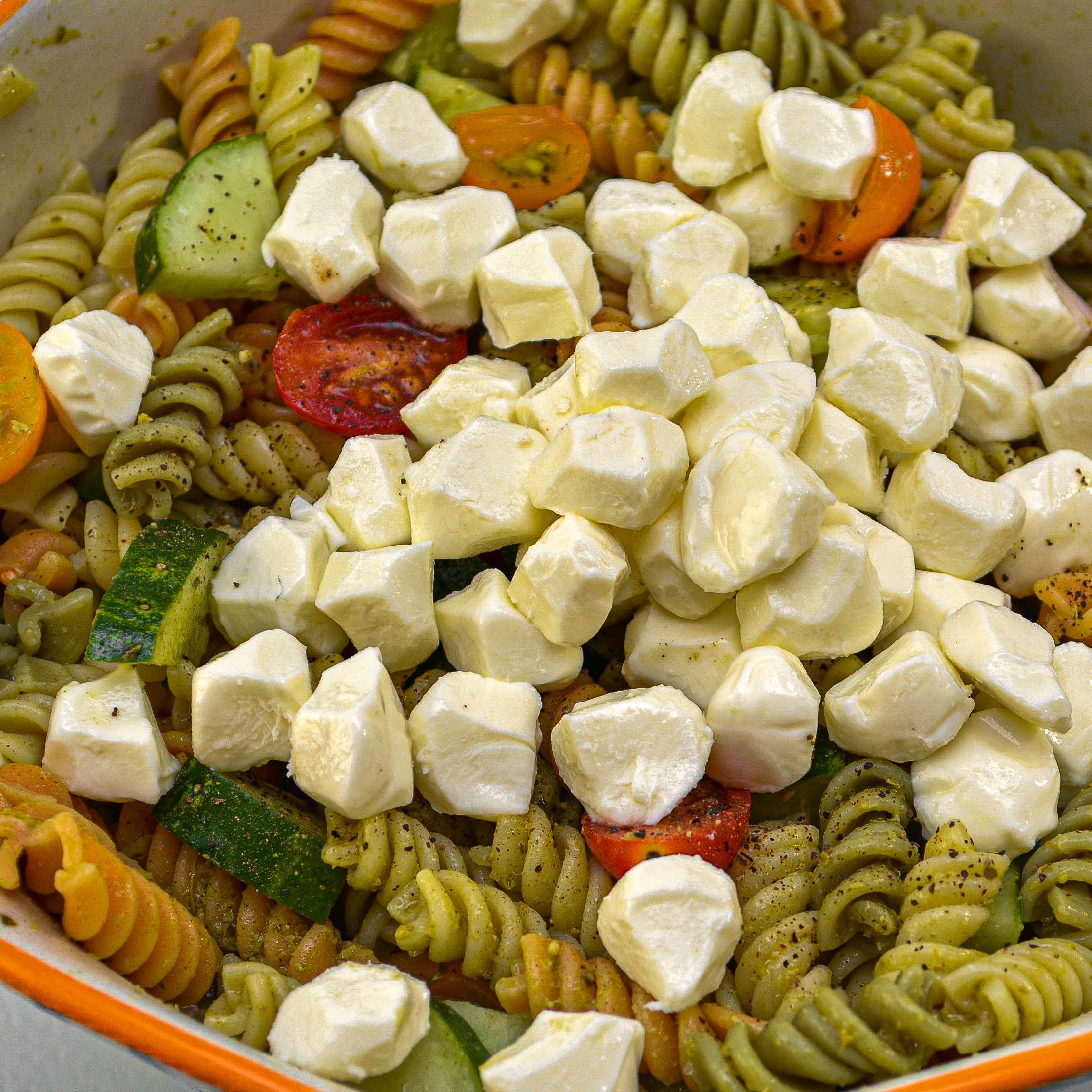 Mix in 6 ounces of fresh mozzarella balls into the pasta salad.