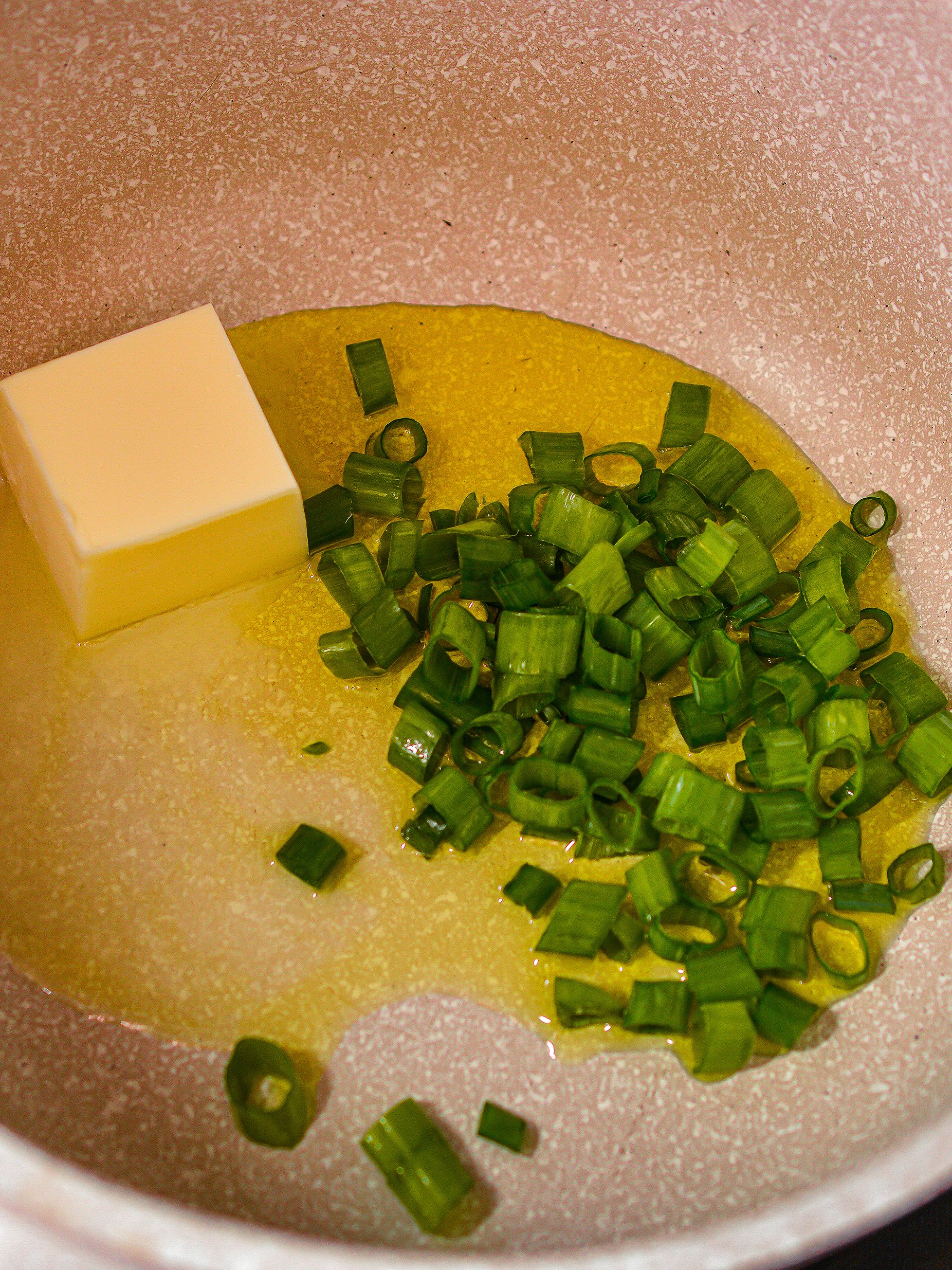 Butter in a saucepan over medium-high heat, and saute the green onions for a minute.