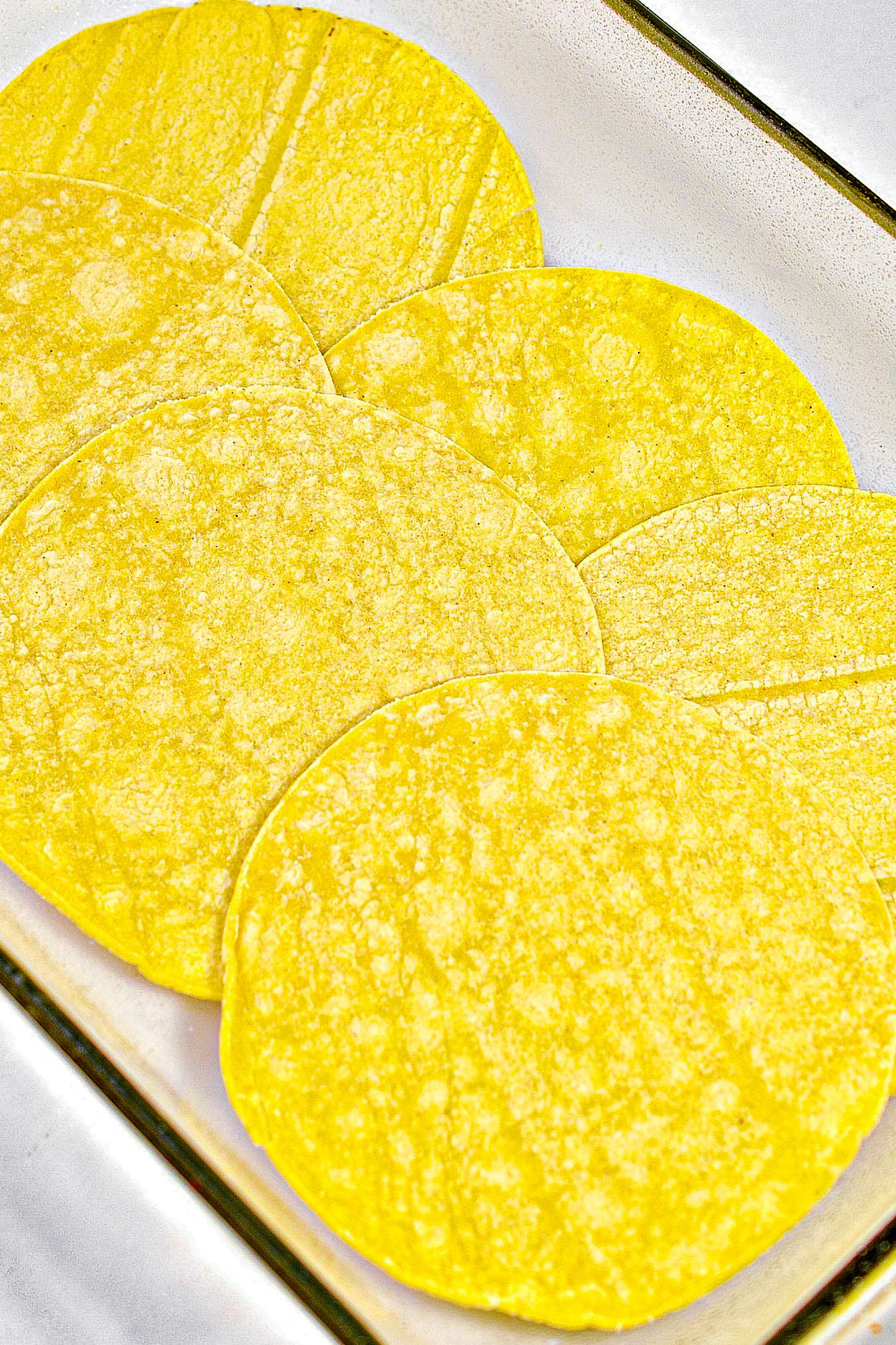 Layer 6 small corn tortillas in the bottom of a well-greased 9x13 baking dish.